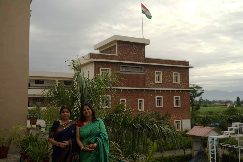 Two teacher of Gyan Einstein in front of flag and bulding on Independence day 